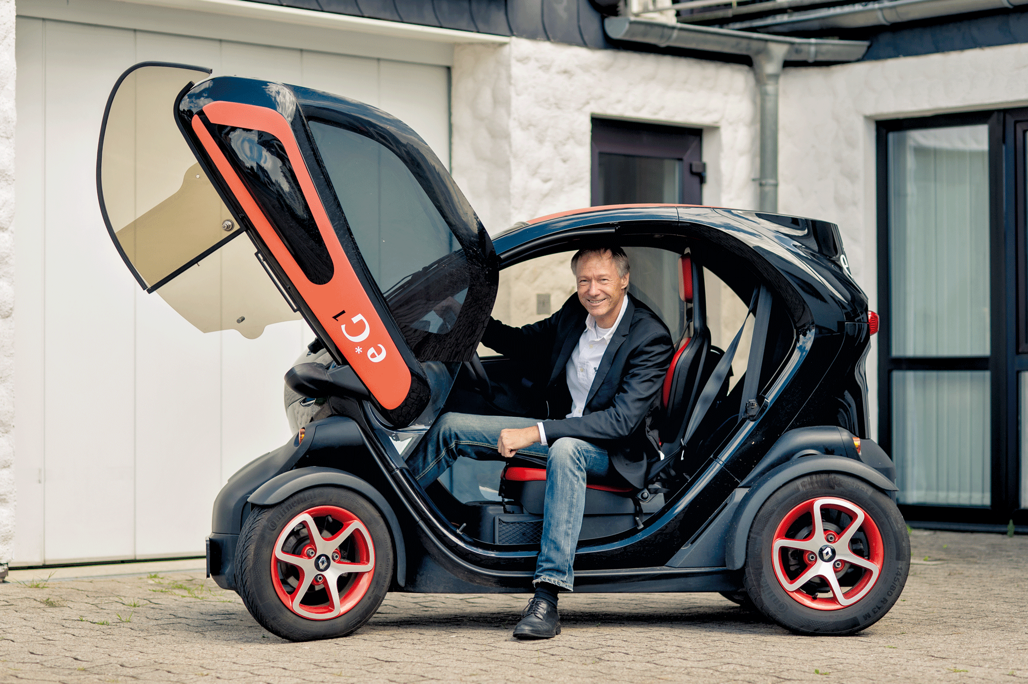 Michael Gillner in seinem elektrischen Kleinfahrzeug vor dem Firmengebäude